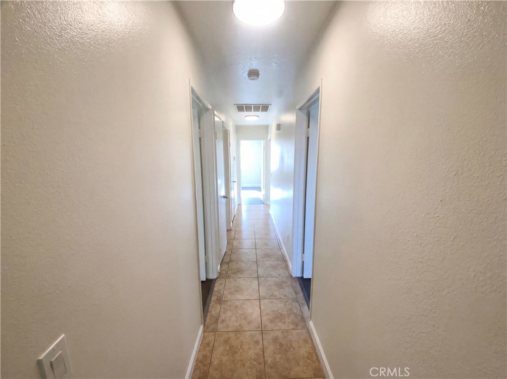 14433 Green River Road Victorville, CA 92394 - Photo 11 of 27 a view of a hallway with wooden floor and a chandelier