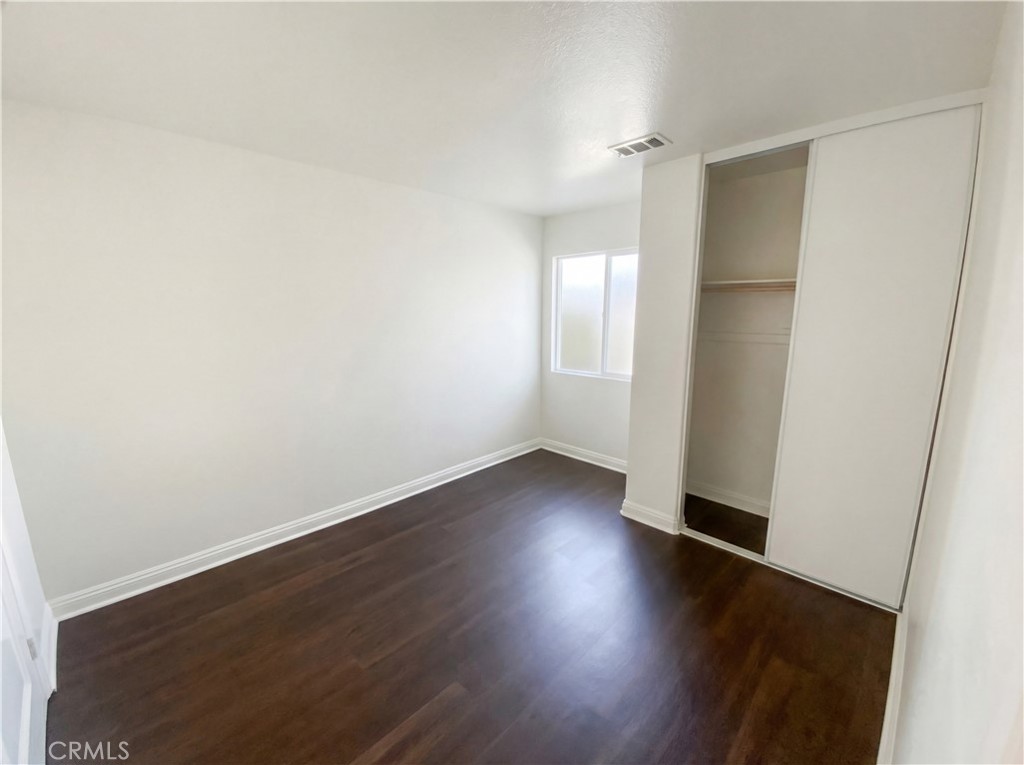 14433 Green River Road Victorville, CA 92394 - Photo 14 of 27 an empty room with wooden floor and windows
