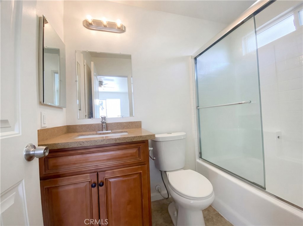 14433 Green River Road Victorville, CA 92394 - Photo 22 of 27 a bathroom with a granite countertop toilet a sink and a mirror
