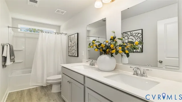 a bathroom with a granite countertop sink a toilet and shower