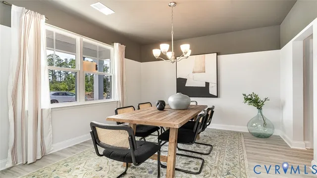 a dining room with wooden floor a chandelier a wooden table and chairs