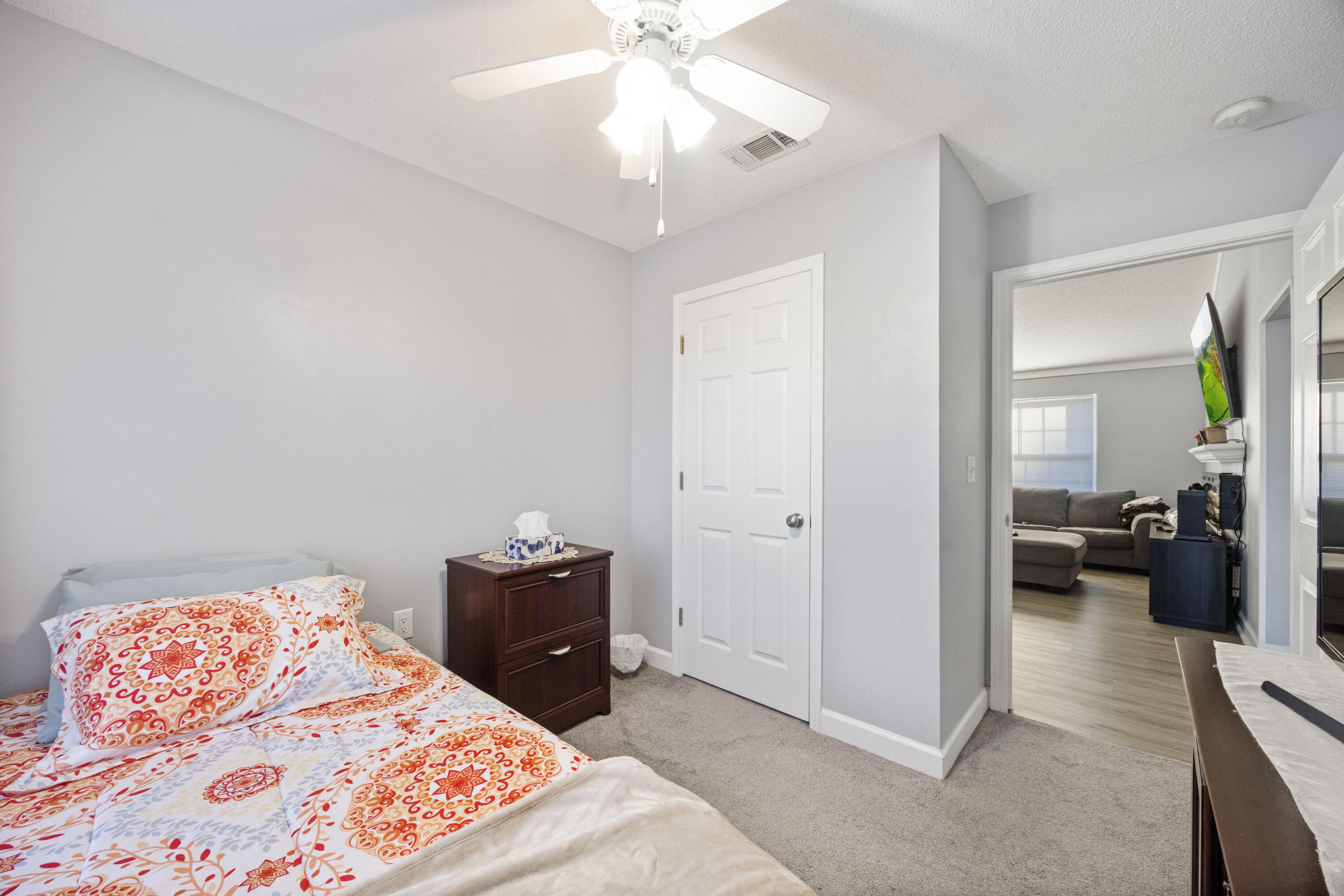 4694 Bobolink Way Crestview, FL 32539 - Photo 11 of 16 a bedroom with a bed and a chandelier