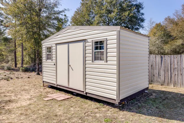 a view of a house with a yard and wooden fence