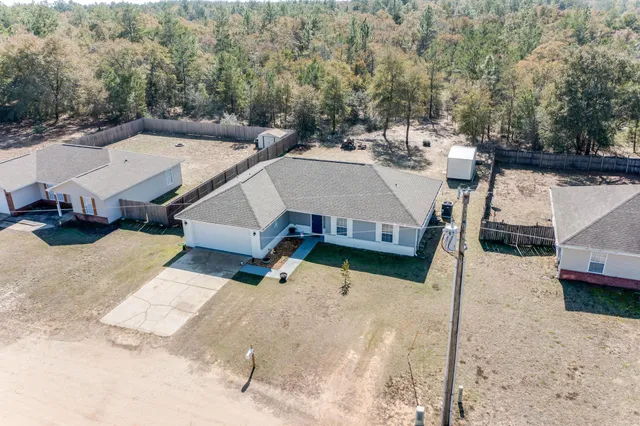 an aerial view of a house with swimming pool and sitting area