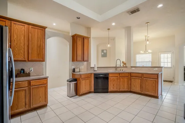 a large kitchen with stainless steel appliances granite countertop a sink and cabinets