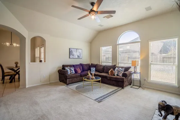 a living room with furniture a couch and paintings on the wall