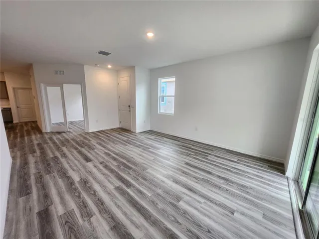 a view of a room with wooden floor and window