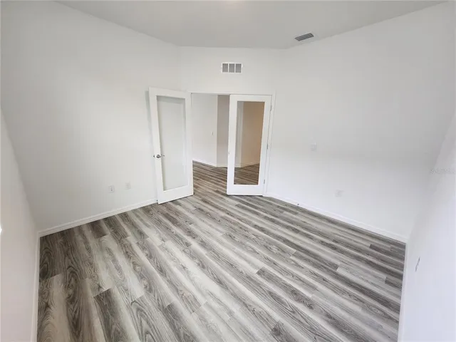 a view of empty room with wooden floor