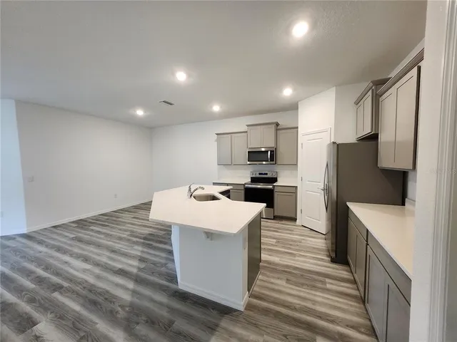 a kitchen with a sink a counter top space stainless steel appliances and cabinets