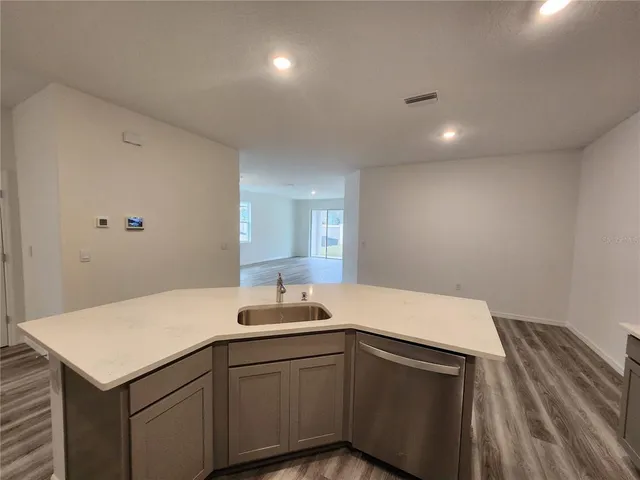 a kitchen with a sink cabinets and wooden floor
