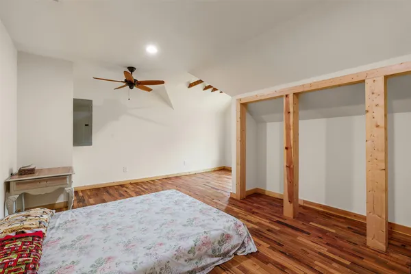 a view of empty room with wooden floor and fan