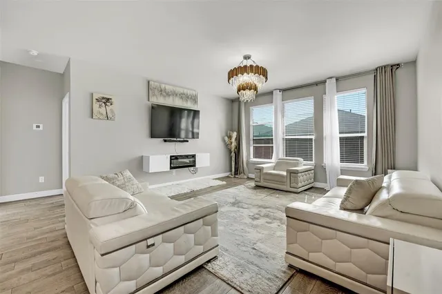 a living room with furniture a flat screen tv and a large window