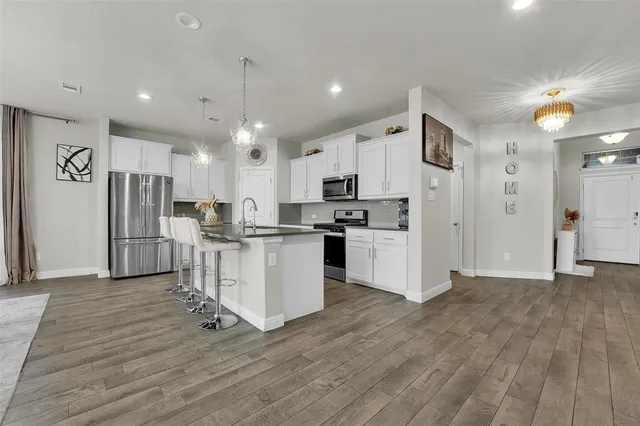 a kitchen with white cabinets and stainless steel appliances