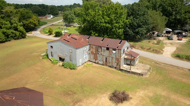 an aerial view of a house with swimming pool and large trees