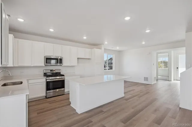 a view of kitchen with microwave stove refrigerator and cabinets