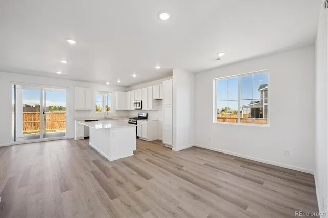 a view of kitchen with wooden floor and electronic appliances