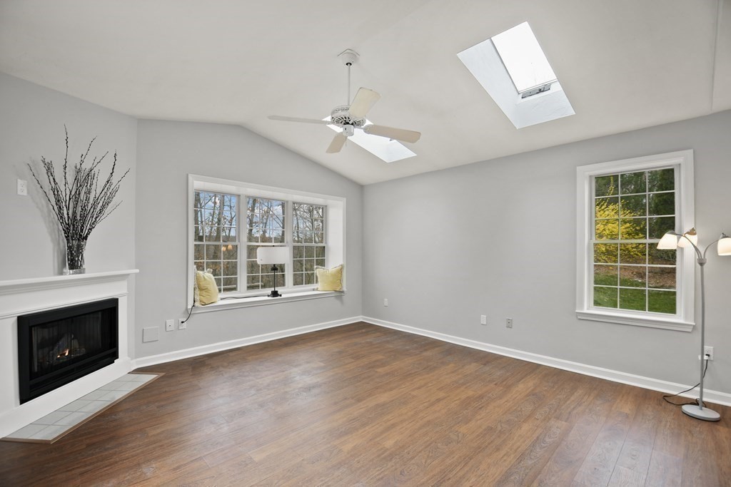 307 Ridgefield Circle, Unit D Clinton, MA 01510 - Photo 19 of 42 an empty room with wooden floor fan and windows