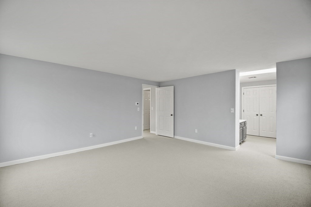 307 Ridgefield Circle, Unit D Clinton, MA 01510 - Photo 32 of 42 a view of an empty room and chandelier fan