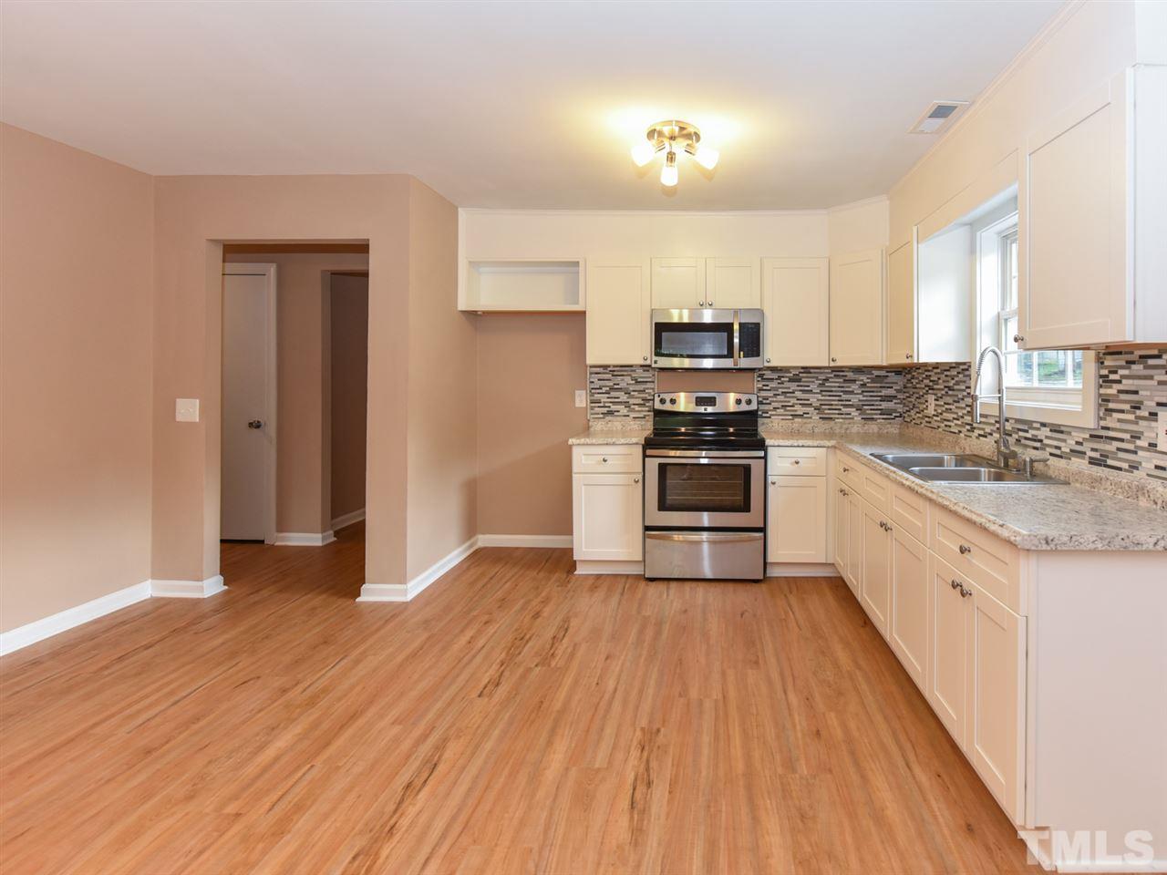 1221 Seabrook Road Raleigh, NC 27610 - Photo 2 of 16 a kitchen with granite countertop wooden floors and stainless steel appliances