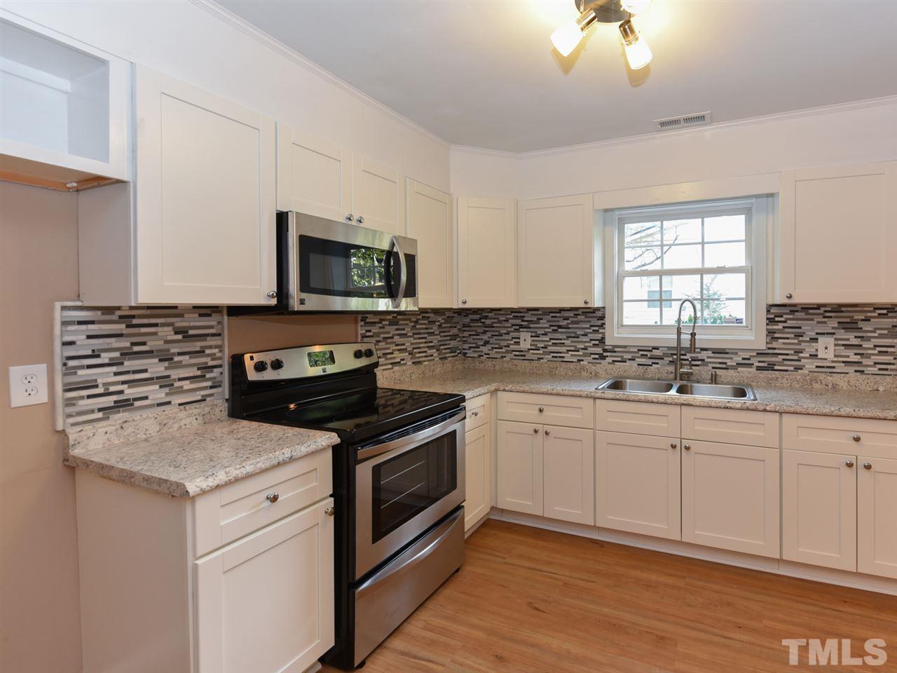 1221 Seabrook Road Raleigh, NC 27610 - Photo 3 of 16 a kitchen with granite countertop a stove sink and microwave