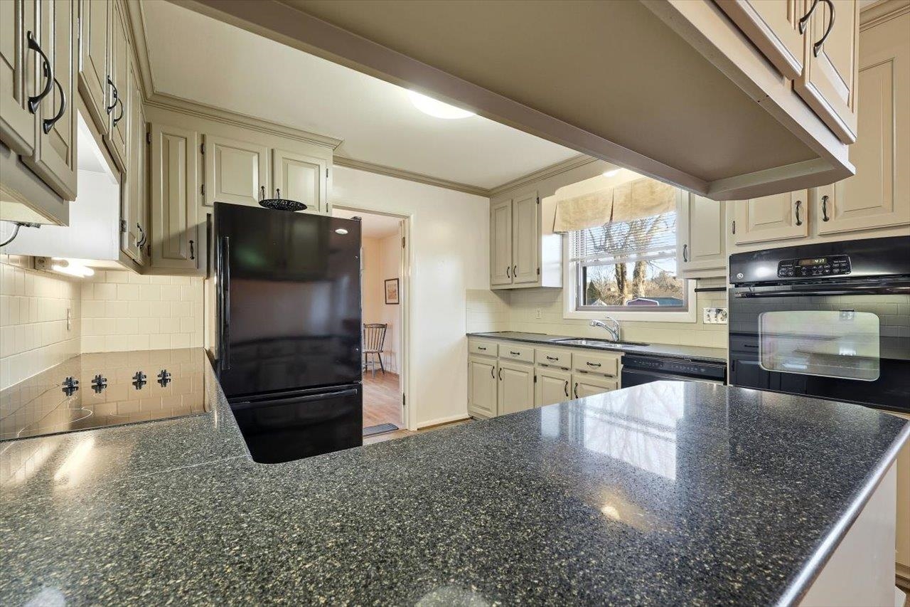 1133 Club Road Waynesboro, VA 22980 - Photo 15 of 58 a kitchen with stainless steel appliances granite countertop a refrigerator a stove and a sink with wooden floors