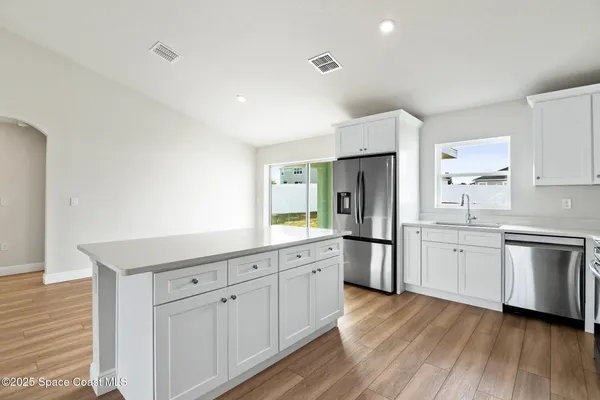 a kitchen with white cabinets and stainless steel appliances