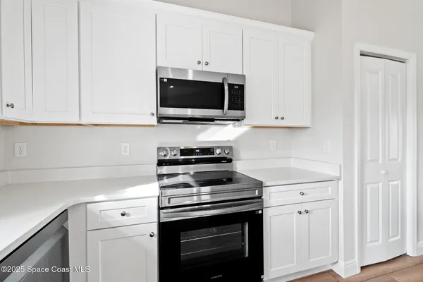 a kitchen with white cabinets and stainless steel appliances