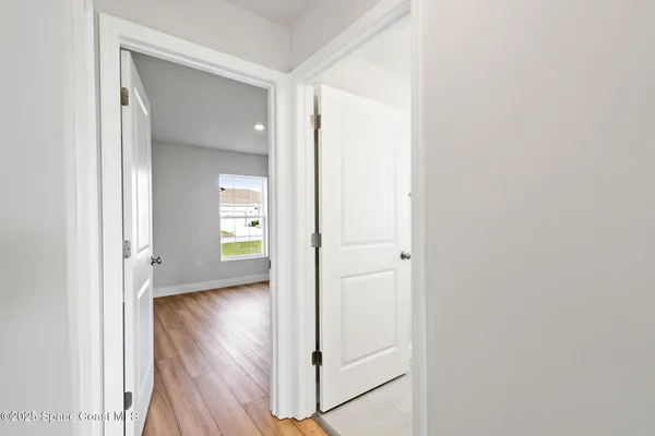 a view of a hallway with wooden floor