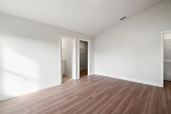 a view of an empty room with wooden floor