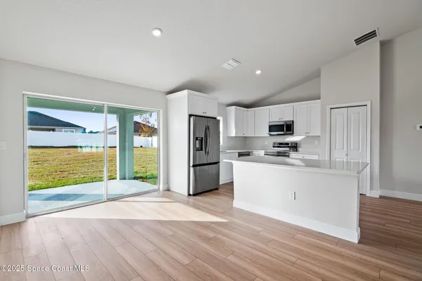 a kitchen with stainless steel appliances a refrigerator sink and microwave