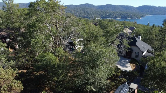 an aerial view of residential house with outdoor space and trees all around
