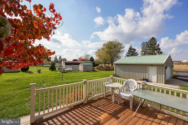 a view of a deck with a big yard and large trees