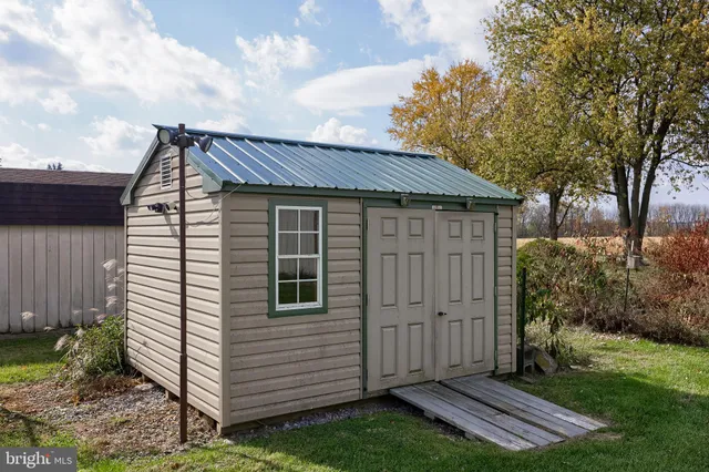 a view of a big house with a big yard and large trees