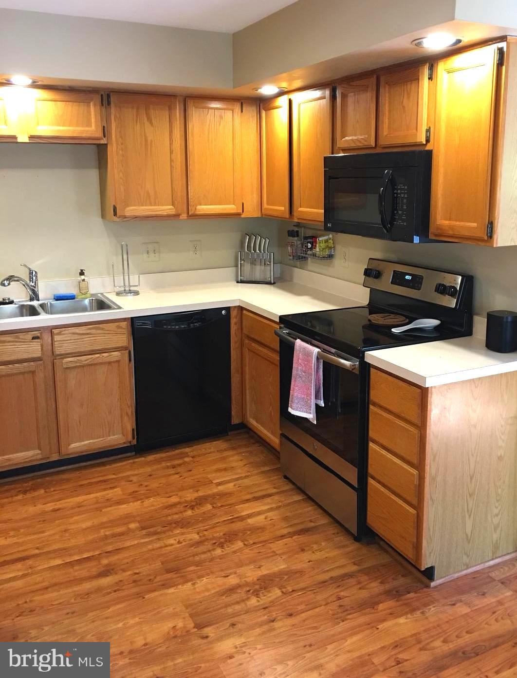 43506 Postrail Square Ashburn, VA 20147 - Photo 14 of 59 Black appliances set off the oak cabinets