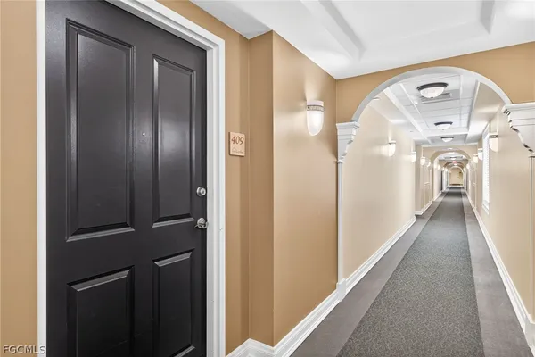 a view of hallway with livingroom and wooden floor