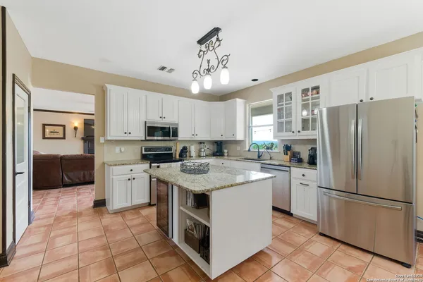 a kitchen with stainless steel appliances granite countertop a refrigerator stove a sink and dishwasher