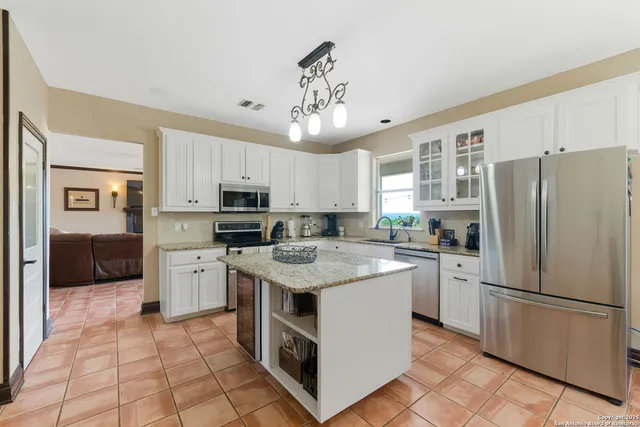 a kitchen with stainless steel appliances granite countertop a refrigerator stove a sink and dishwasher