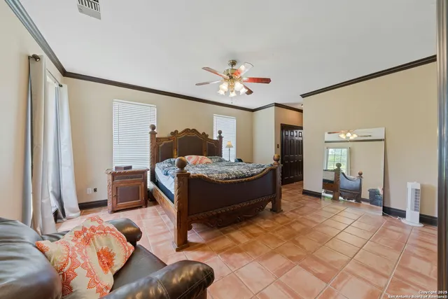 a spacious bedroom with a bed and a chandelier