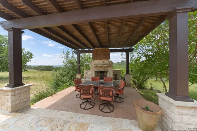 a view of a patio with table and chairs potted plants with floor to ceiling window