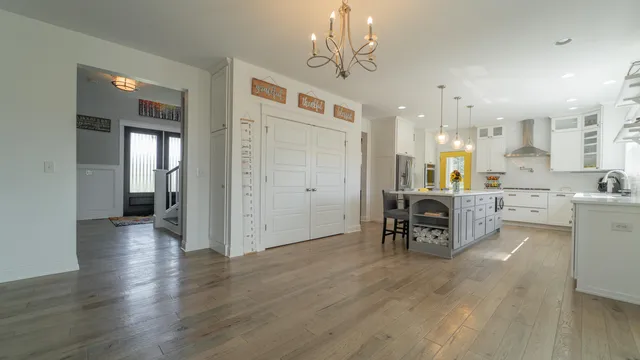 a kitchen with a dining table chairs stainless steel appliances and cabinets