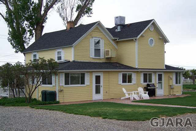 3530 G Road Palisade, CO 81526 - Photo 4 of 25 a front view of a house with a yard and garage