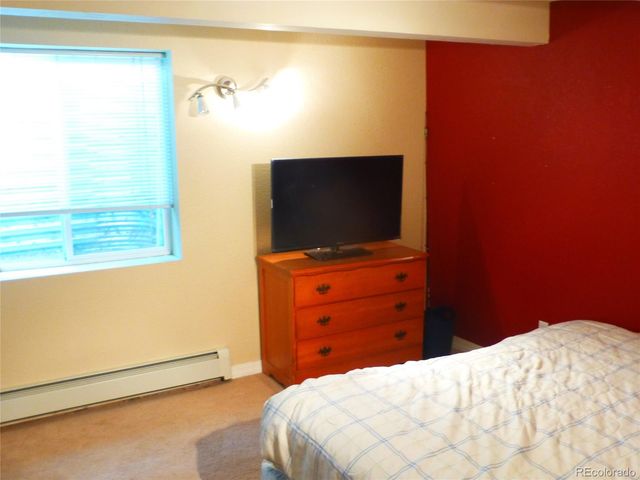 a blue bed sitting in a bedroom next to a window