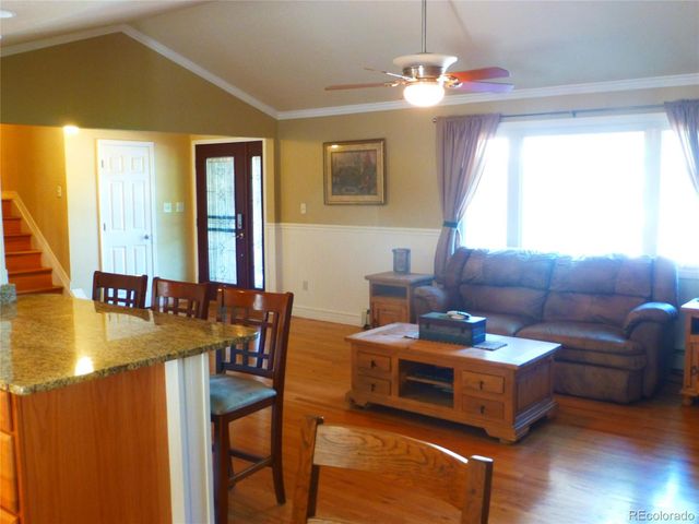 a kitchen with stainless steel appliances granite countertop a refrigerator a stove and a sink with wooden floor