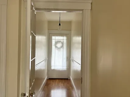a view of a hallway with wooden floor