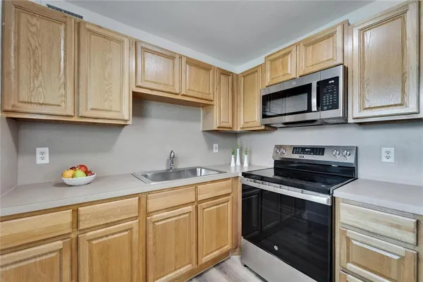 a kitchen with stainless steel appliances granite countertop a sink stove and microwave