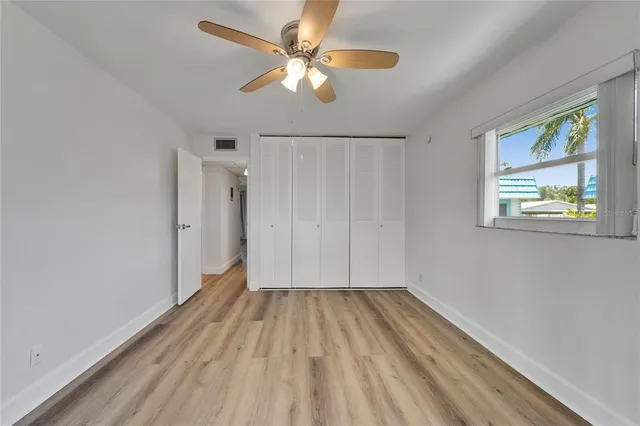 a view of room with hardwood floor and a ceiling fan