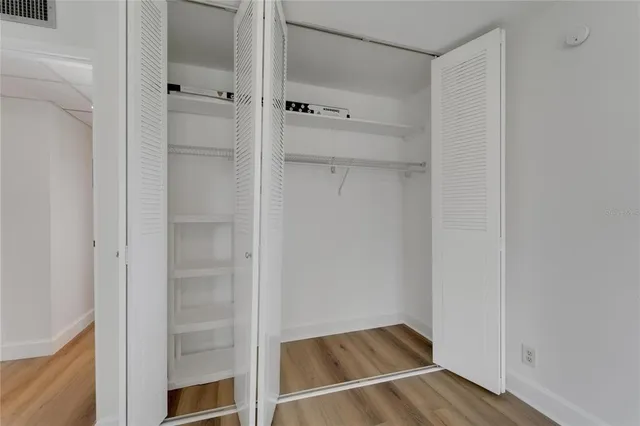 a view of walk in closet with empty racks