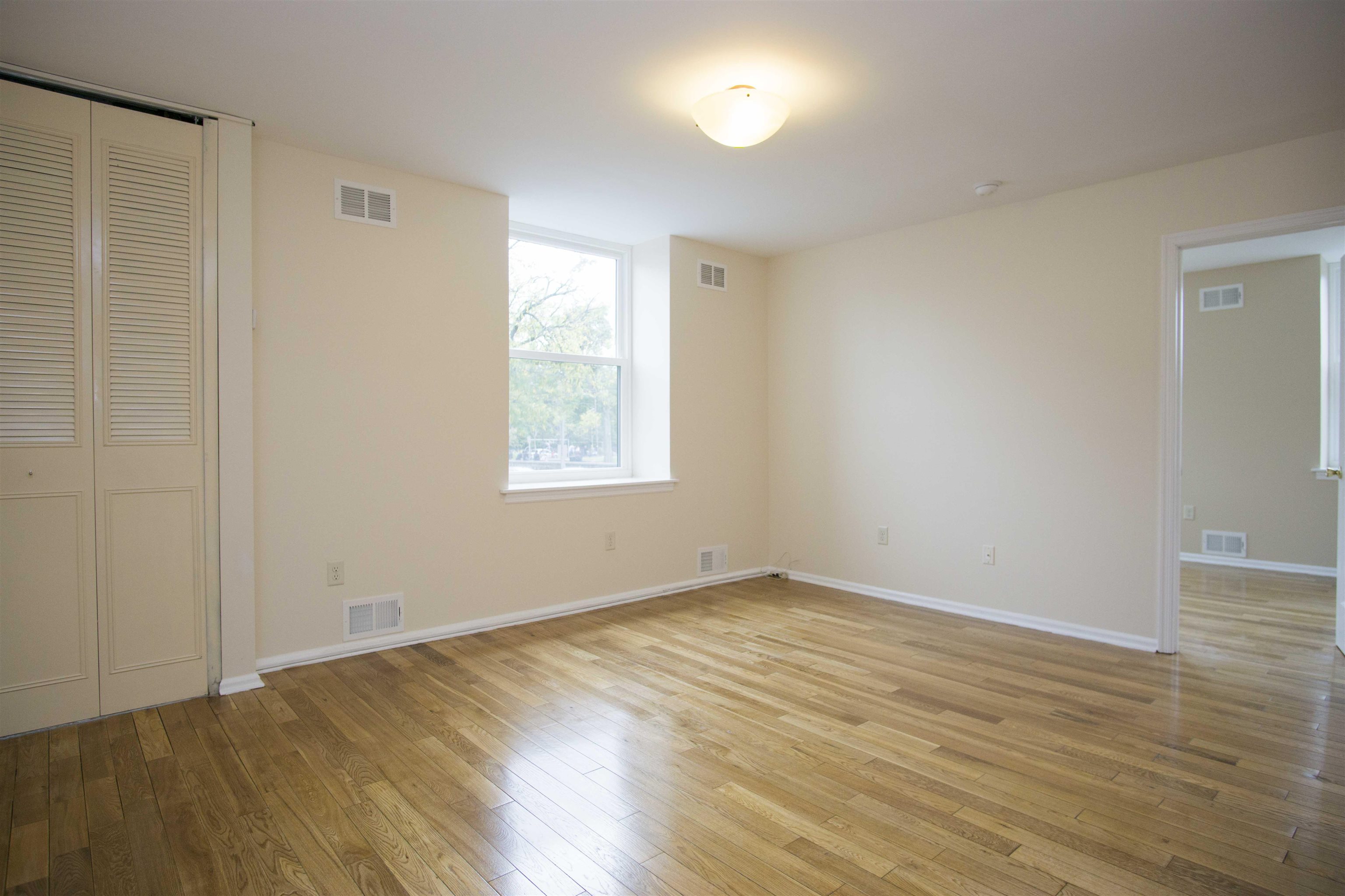 200 Central Avenue, Unit B5 Jersey City, NJ 07307 - Photo 5 of 12 an empty room with wooden floor and windows