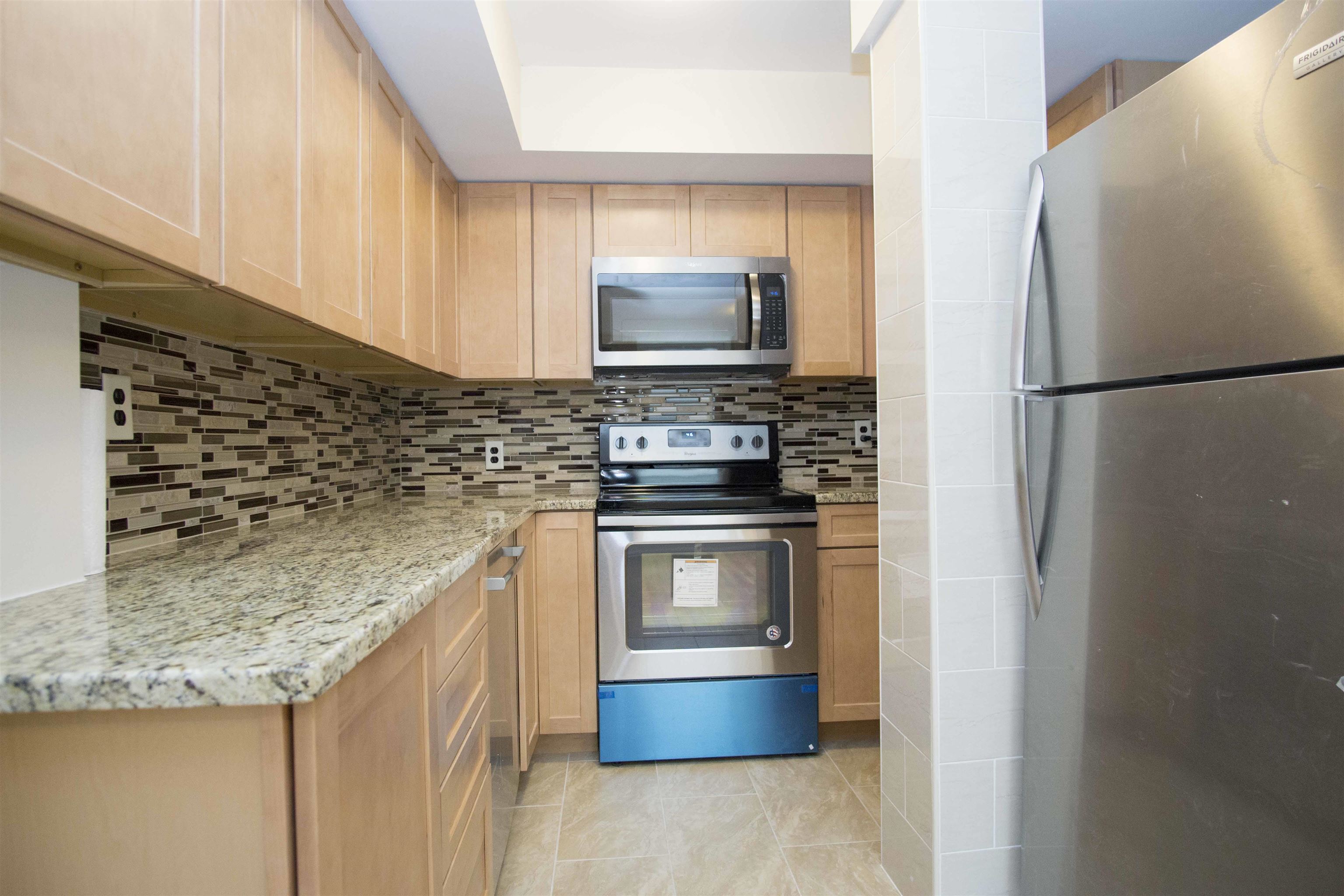200 Central Avenue, Unit B5 Jersey City, NJ 07307 - Photo 7 of 12 a kitchen with stainless steel appliances granite countertop a refrigerator and a stove top oven