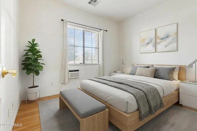 a spacious bedroom with a bed and a potted plant